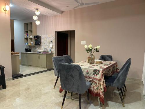 a dining room with a table and chairs and a kitchen at Shamiyana Homestay Tura in Tura