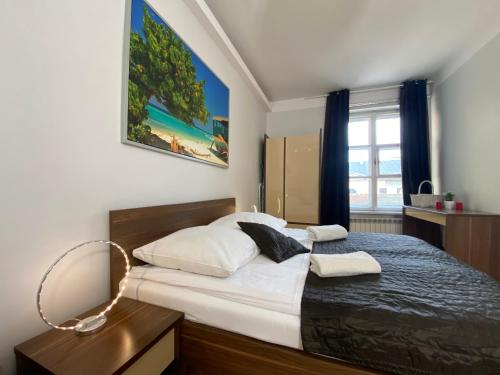 sypialnia z dużym łóżkiem z białymi prześcieradłami w obiekcie Apartments Legendary Kraków w Krakowie