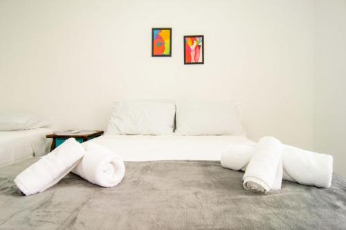ein weißes Sofa mit gerollten Handtüchern in einem Zimmer in der Unterkunft Ótima localização, Apto NOVO no Bay Village KQ8551 in Balneário Camboriú