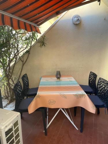 une table et des chaises assises sur une terrasse dans l'établissement Charmant studio Residence Carnon plage-Climatisation-Parking Prive, à Carnon-Plage