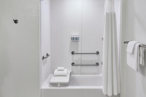 a white bathroom with a toilet and a shower at Courtyard by Marriott St. Petersburg Clearwater/Madeira Beach in St Pete Beach