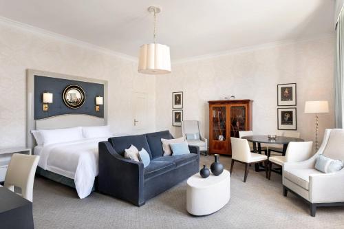 a bedroom with a bed and a living room at Hotel Bristol, A Luxury Collection Hotel, Warsaw in Warsaw