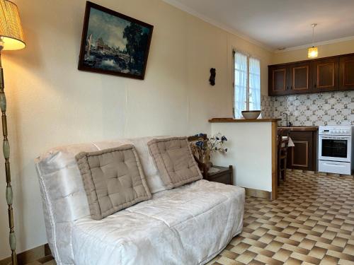 un salon avec un canapé blanc et une cuisine dans l'établissement 483 - Maison 5p à 250m de la Plage de Caroual, à Erquy