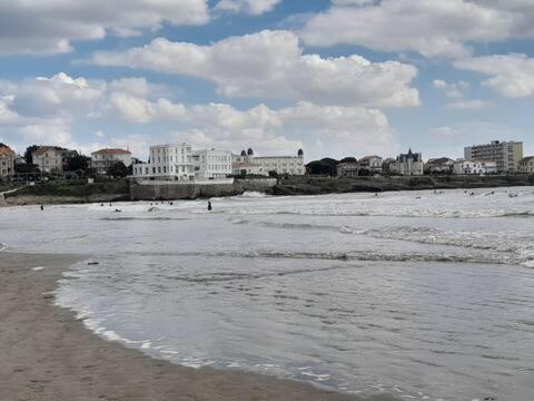 a beach with a group of people in the water at Appartement PONTAILLAC- ROYAN in Pontaillac
