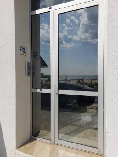 d'une porte coulissante en verre offrant une vue sur l'océan. dans l'établissement Appartement PONTAILLAC- ROYAN, à Pontaillac
