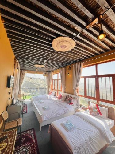 a bedroom with two beds and a large window at Al Misfah Hospitality Inn in Misfāh