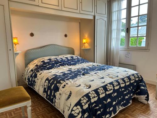 une chambre avec un lit avec une couette bleue et blanche dans l'établissement 483 - Maison 5p à 250m de la Plage de Caroual, à Erquy