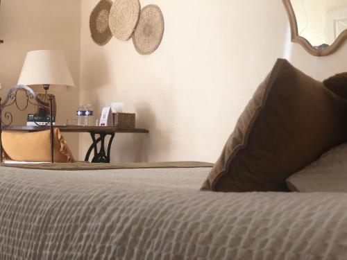 a bedroom with a bed and a table with a lamp at Logis hôtel et restaurant La Bastide Cabezac in Bize-Minervois