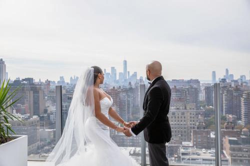 a bride and groom holding hands on top of a building at Fairfield Inn & Suites by Marriott New York Midtown Manhattan/Penn Station in New York