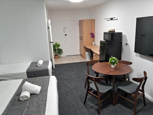 a small living room with a table and a television at Mid City Motor Inn in Mackay