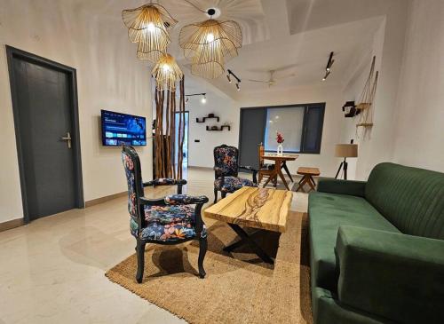 a living room with a green couch and a table at Luxury home with projector room near Kasauli in Dagshai