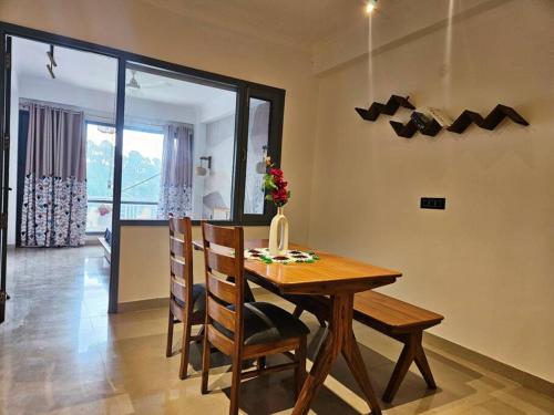 a dining room with a wooden table and chairs at Luxury home with projector room near Kasauli in Dagshai