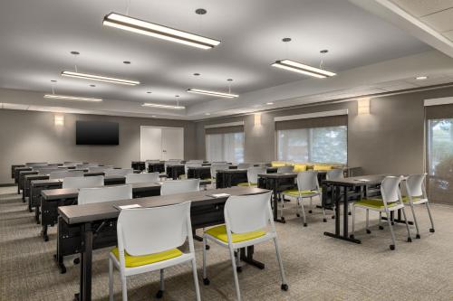 a conference room with tables and chairs and a screen at SpringHill Suites By Marriott Columbia Fort Meade Area in Columbia
