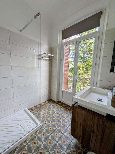 une salle de bain avec une baignoire, un lavabo et une fenêtre dans l'établissement Pagliano, à Manosque