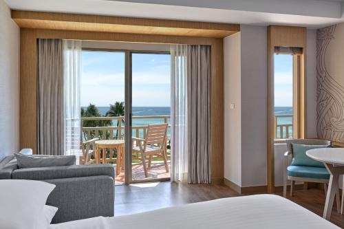 a hotel room with a bed and a view of the ocean at Phuket Marriott Resort & Spa, Merlin Beach in Patong Beach