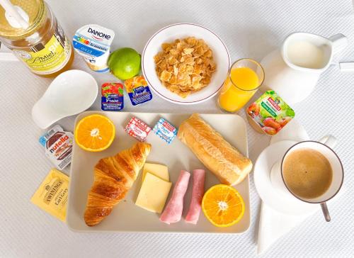 a tray of food with breakfast foods and a cup of coffee at Le National Sète Centre Gare,Ascenseur in Sète