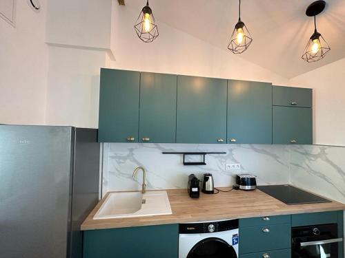 une cuisine avec des armoires bleues et un évier dans l'établissement Appart cosy - belle vue, à Niort