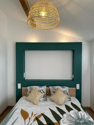 - une chambre avec un lit à tête verte dans l'établissement Appart cosy - belle vue, à Niort
