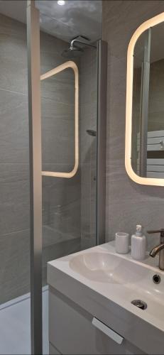 une salle de bain avec un lavabo blanc et une douche dans l'établissement Charmant appartement T3 plein centre, à Luchon