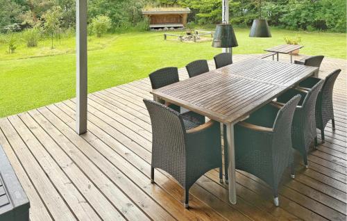 une terrasse en bois avec une table et des chaises en bois dans l'établissement Holiday Home Gyvelvænget Glesborg Ii, à Fjellerup Strand