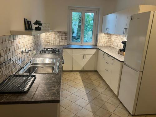 a kitchen with a sink and a refrigerator at Cozy 2-Bedroom Retreat Near Subway and City Center in Vienna