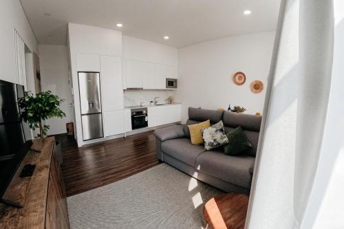 a living room with a couch and a kitchen at Apartmento elegante in Figueira da Foz