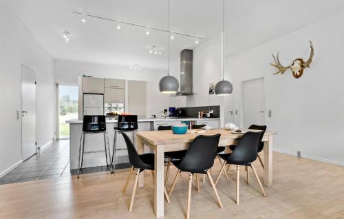 a kitchen and dining room with a wooden table and chairs at 3 Bedroom Gorgeous Home In Ålbæk in Ålbæk