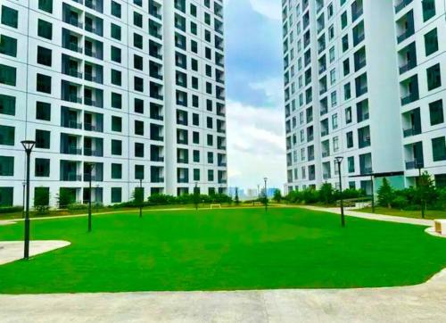 a large green field in front of two tall buildings at 3R2B KSL2 Midvalley Southkey Ikea Toppen Aeon in Johor Bahru