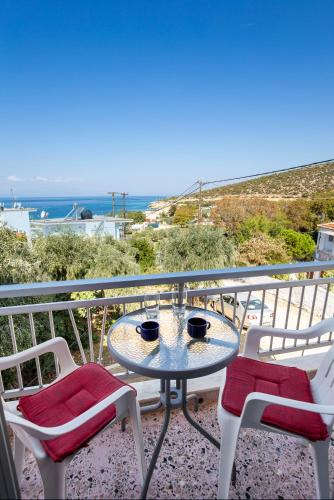 a table and chairs on a balcony with a view of the ocean at "Thea" Apartment 2 in Skala Marion