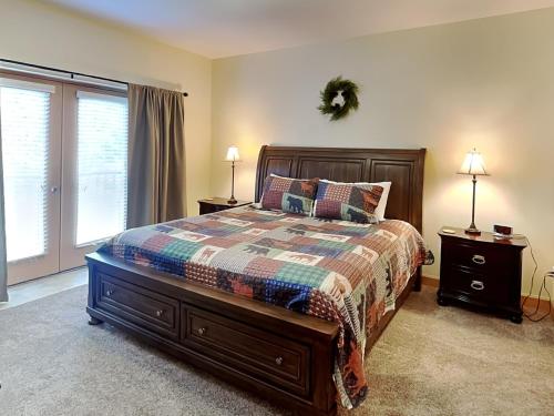 Un dormitorio con una cama y dos lámparas y una ventana. en Hi-Bear-Nate Mountain View 5303, en Pigeon Forge