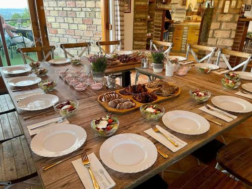 a long wooden table with plates and bowls of food at Private Villa with indoor pool in Budapest
