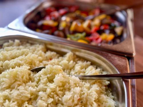 a plate of rice with a spoon in it and a tray of food at Private Villa with indoor pool in Budapest