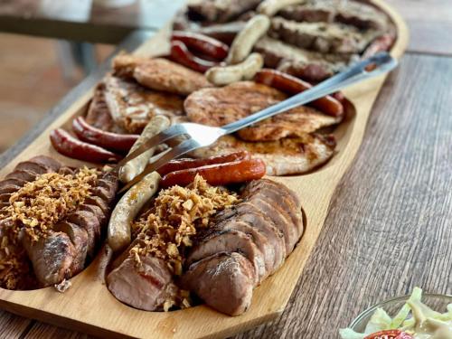 a wooden cutting board with sausages and other foods at Private Villa with indoor pool in Budapest