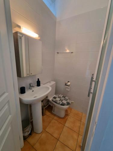 une salle de bain blanche avec un lavabo et des toilettes dans l'établissement Airial landais, à Sanguinet