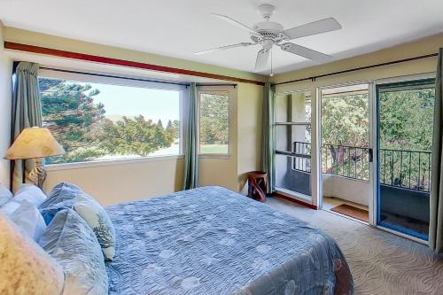 a bedroom with a bed and a large window at Paniolo Greens at Waikoloa C212 in Waikoloa Village