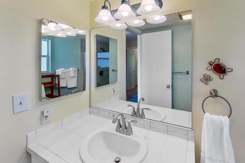a bathroom with a sink and a large mirror at Paniolo Greens at Waikoloa C212 in Waikoloa Village