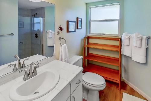 a bathroom with a sink and a toilet and a window at Paniolo Greens at Waikoloa C212 in Waikoloa Village