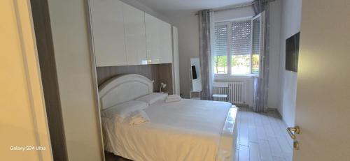 a bedroom with a white bed and a window at Orchidea di Tatiana in Bologna