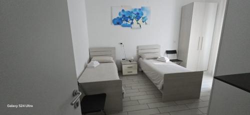 a small room with two beds and a table at Orchidea di Tatiana in Bologna