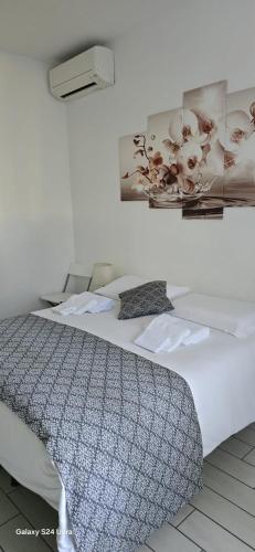 a bedroom with a large white bed in a room at Orchidea di Tatiana in Bologna