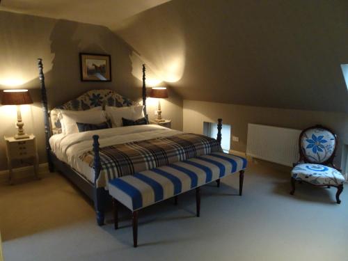 a bedroom with a large bed and a chair at The Loch Lomond Arms Hotel in Luss