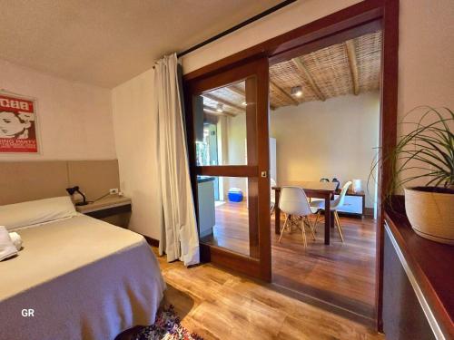 Un dormitorio con una cama y un comedor con una mesa. en Casa Cavalo Marinho - Superconfortável! Perto de tudo, longe do tumulto., en Arraial d'Ajuda