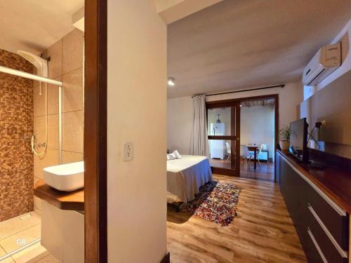 una habitación de hotel con una cama y un baño en Casa Cavalo Marinho - Superconfortável! Perto de tudo, longe do tumulto., en Arraial d'Ajuda