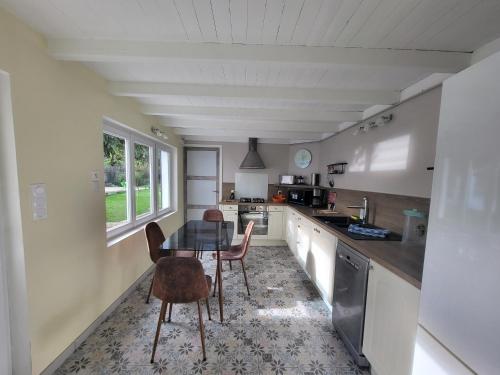 a kitchen with a table and chairs in a room at La marine D'opale in Ambleteuse