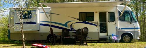 a white and blue rv parked in the grass at Stinnett Family Farm in Stockbridge