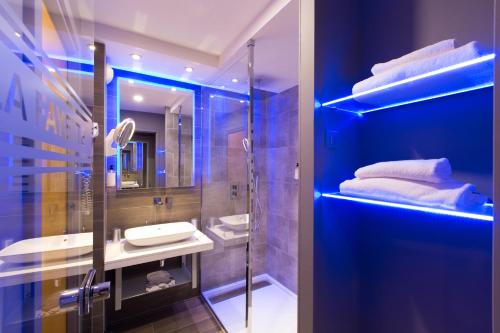a bathroom with a shower and a sink and a mirror at Best Western Plus La Fayette Hotel et SPA in Épinal