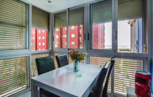 a dining room with a table and chairs and windows at One-Bedroom Apartment In La Pobla De Farnals in Masalfasar