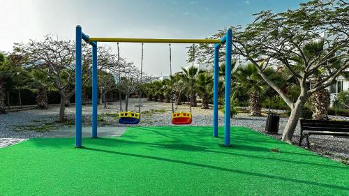 a playground with a swing set in a park at Вилла в жилом комплексе Caesar Beach V16L in Boğaz