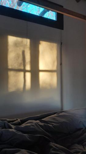 a bedroom with a window with a shadow of a bed at Chakana Hospedaje Rural in Villa Unión