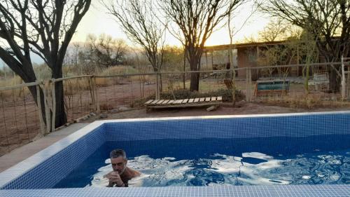 a man is in a swimming pool in aificialificialificialificialificialificialificial at Chakana Hospedaje Rural in Villa Unión
